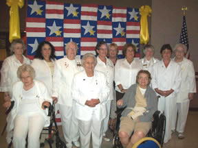 Gold Star Moms standing in front of a red white and blue quilt with Gold Stars