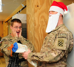 soldier in santa hat handing package to another soldier